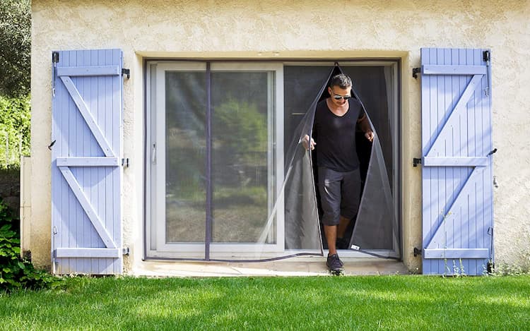 homme en noir qui sort par une moustiquaire pour baie vitrée tranquilisafe 